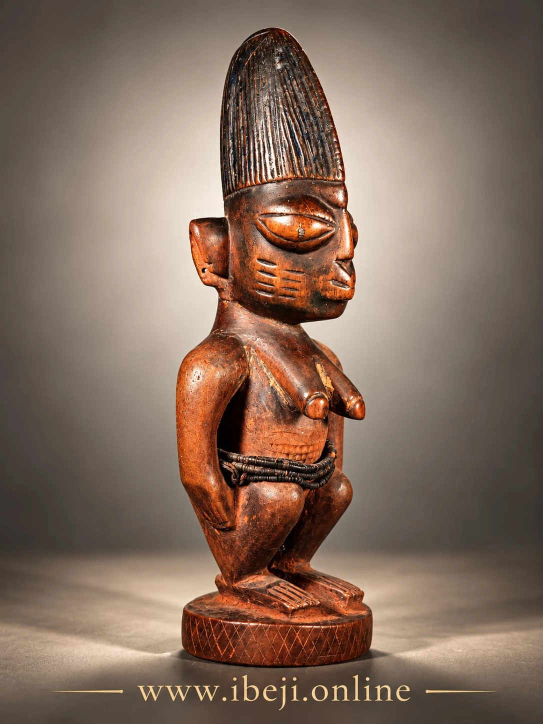 Figura Ibeji de madera vista en tres cuartos, con cofia estriada y pedestal circular